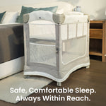Mother reaching to her baby in the Mini Ezee 3-in-1 Co-Sleeper beside her bed