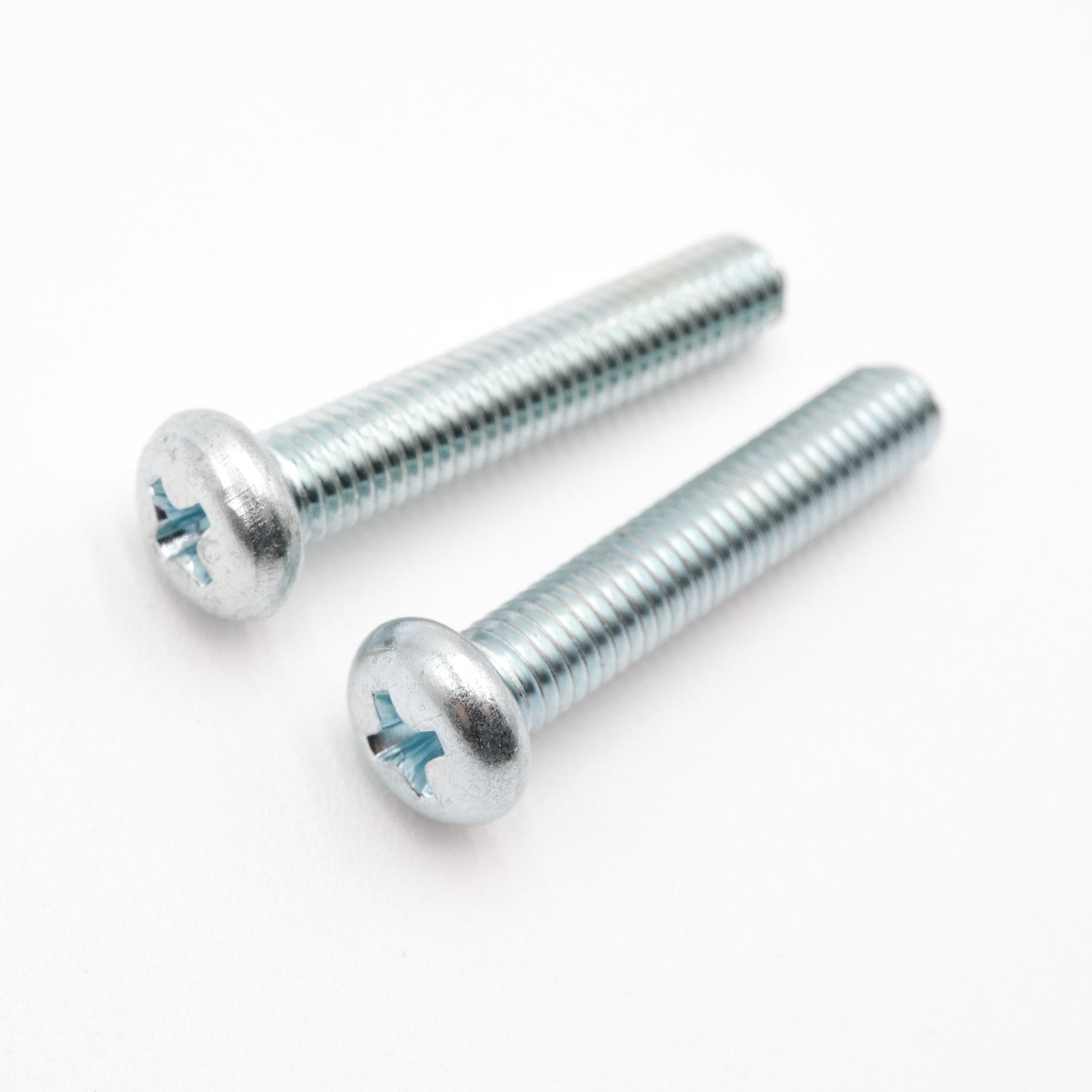 Two metal screws on a white background